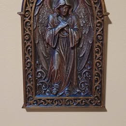 Decorative wall art with an angel figure on a beige background