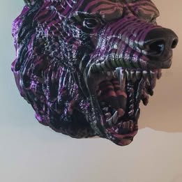3D-printed creature head sculpture with purple and black colors on a white background
