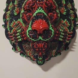Decorative lion with intricate designs in green, red, and black on a white background