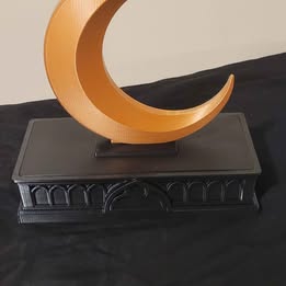 Decorative object with a crescent moon design on a black background