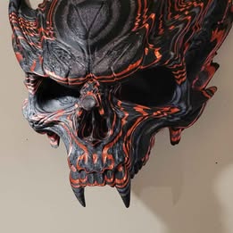 Decorative skull with black and orange design on a plain background