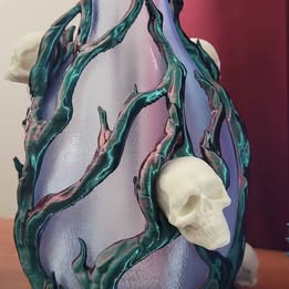 Decorative piece with skull and tree design on a purple background